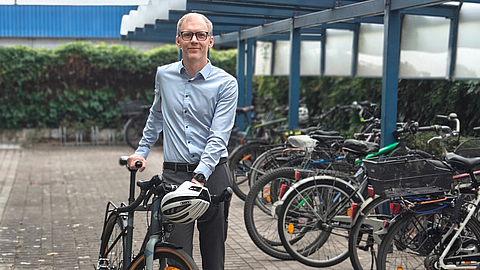 Henrik Habenicht mit seinem Fahrrad an den Fahrradständern