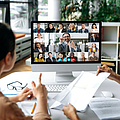 Zwei Frauen sitzen an einem Schreibtisch vor einem Bildschirm, auf dem mehrere Menschen bei einer Online-Konferenz zu sehen sind. | © Kateryna - stock.adobe.com Zwei Frauen sitzen an einem Schreibtisch vor einem Bildschirm, auf dem mehrere Menschen bei einer Online-Konferenz zu sehen sind.