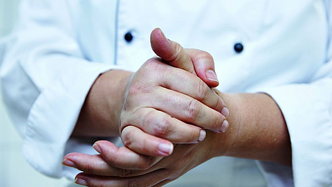 Mann cremt sich die Hände ein