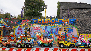 ... das Kinderkarussell „Euro Car“ mit einem deutschen und einen polnischen Mitarbeiter. | © BGN | Ellen Weidenfeld Das Kinderkarussell Euro-Car von Marco Sottile