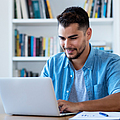 Junger Mann arbeitet am Laptop