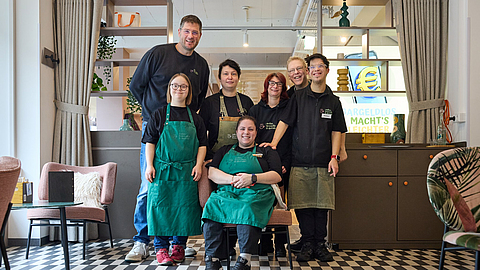 Stolz auf sein Team: Max C. Luscher (hinten links) mit Betriebsleiterin Kathrin Dorn und den Mitarbeitenden Kerstin Steinmacher, Florian Russ, Matheo Schultheis, Marleen Bailer und Svenia Wissmann (von links nach rechts). | © Dominik Buschardt Caféinhaber Max C. Luscher (hinten links) mit Mitarbeitenden seines Teams bei Coffee, Brownies and Downies