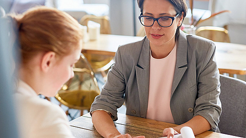 Junges Mädchen unterschreibt Vertrag nach Interview mit der Besitzerin eines Cafés