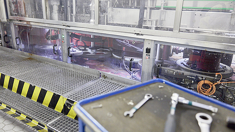 Werkzeugwagen steht vor einer Anlage