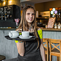 Porträt einer jungen Kellnerin, die im Café steht
