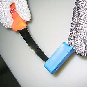 Messerprüflehre: Die Messerspitze schaut hier aus der Prüflehre nicht heraus, also ist alles in Ordnung. | © BGN / Winkler Richtiger Umgang mit der Messer-Prüflehre