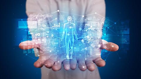 Junge Person, die eine Hologrammprojektion mit gesundheitsbezogenen Grafiken und Symbolen hält