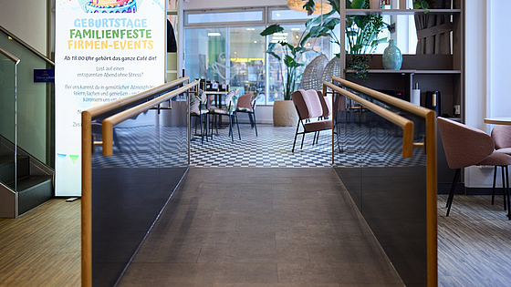 Verschiedenen Sitzmöglichkeiten laden in dem hellen, geräumigen Café zum Bleiben ein. Eine Rampe ermöglicht den barrierefreien Zugang. | © Dominik Buschardt Das Inklusionscafé Coffee, Brownies and Downies ist barrierefrei zugänglich