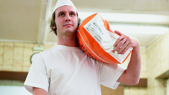 Bäcker trägt Mehlsack