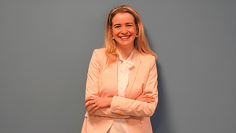 Iris Bauer vor einer Wand | © BGN | Ellen Weidenfeld Iris Bauer vor einer Wand