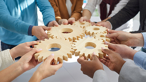 Team von Leuten, die Zahnräder verbinden | © Studio Romantic - stock.adobe.com Team von Leuten, die Zahnräder verbinden