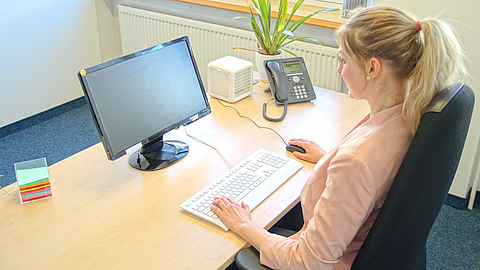 Frau am Bildschirmarbeitsplatz im Büro
