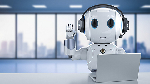 Lächelnder und winkender Roboter mit einem Laptop