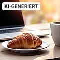 Frisches, leckeres Croissant und eine Tasse Kaffee vor dem Hintergrund des Arbeitsplatzes