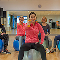 Gruppe trainiert mit Hanteln auf dem Gymnastikball