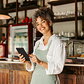 Unternehmerin mit einem digitalen Tablet in ihrem Café