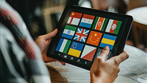 Eine Übersetzungs-App auf einem Tablet zeigt die Flaggen verschiedener Länder an.