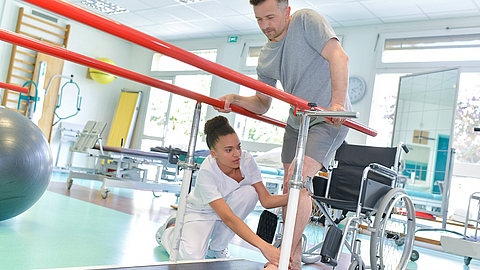 Therapeutin hilft Patienten beim Gehen | © auremar - stock.adobe.com Therapeutin hilft Patienten beim Gehen