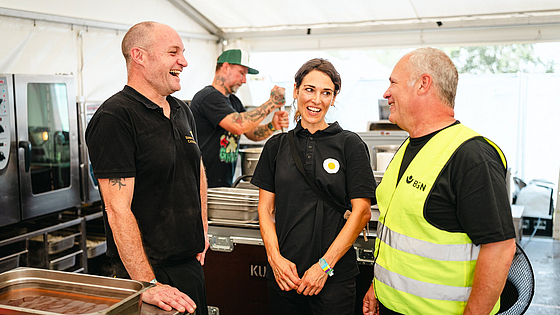 Paul Cusack und Clara Seipp von Sunny Side Catering im Austausch mit BGN-Arbeitsschutzexperte Stephan Thomassohn.