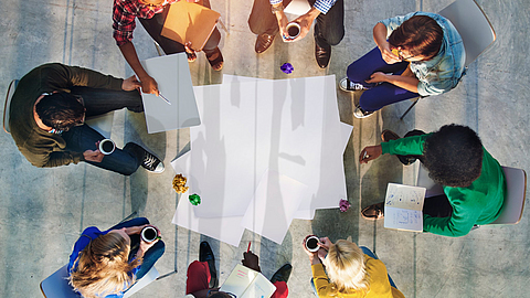 Mitarbeiter sitzen im Kreis und besprechen ein Projekt