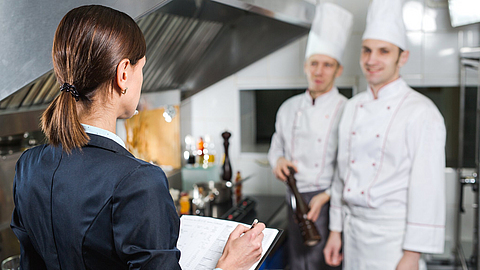 Einweisung des Restaurantleiters an sein Küchenpersonal in der Großküche