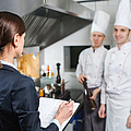 Einweisung des Restaurantleiters an sein Küchenpersonal in der Großküche