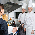 Einweisung des Restaurantleiters an sein Küchenpersonal in der Großküche