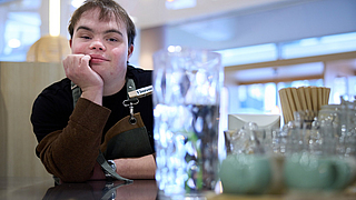 Mitarbeiter Vincent Lang genießt ein paar ruhige Minuten, bevor es weitergeht. | © Dominik Buschardt Mitarbeiter Vincent Lang im Inklusionscafé Coffee, Brownies and Downies