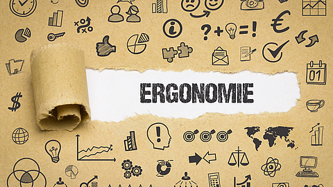 Kraftpapier mit Symbolen rund um den Begriff Ergonomie in der Mitte