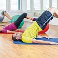 Mehrere Personen liegen auf Gymnastikmatten und trainieren