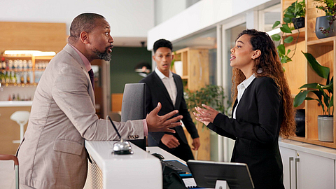 Streitgespräch an der Hotelrezeption | © peopleimages.com - stock.adobe.com Streitgespräch an der Hotelrezeption