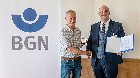 Dr. Katzenberger-Apel (links) erhält von Holger Roth die Silberne Ehrenmedaille. | © BGN Dr. Katzenberger-Apel (links) erhält von Holger Roth die Silberne Ehrenmedaille.