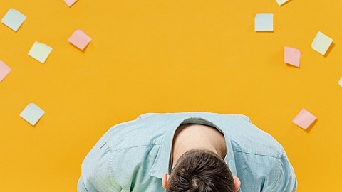 Erschöpfter Mann hat den Kopf auf seinem Schreibtisch und schläft