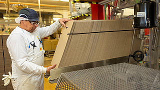 Mitarbeiter befüllt Verpackungsanlage im Maggi-Werk Singen