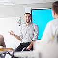 Ein Berufsschullehrer steht vor einer Klasse und erklärt etwas | © pressmaster - stock.adobe.com Ein Berufsschullehrer steht vor einer Klasse und erklärt etwas