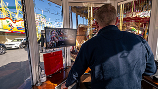 Schausteller Toni Bienert hat über den Überwachungsbildschirm das Geschehen auf dem Venetian Carousel im Blick