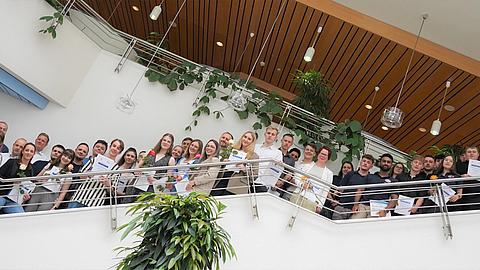 Gruppenfoto der Azubis mit Urkunden auf der Treppe