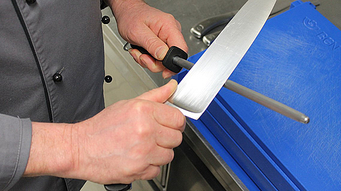 Mit einem Wetzstahl wird ein Messer geschliffen. | © BGN Mit einem Wetzstahl wird ein Messer geschliffen.