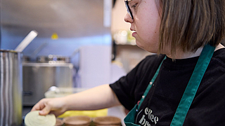 … hier bereitet Marleen kleine Kuchen zum Aufbacken vor. | © Dominik Buschardt Praktikantin Marleen Bailer im Inklusionscafé Coffee, Brownies and Downies