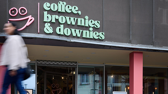Die lächelnde Tasse im Logo ist Programm: Das Inklusionscafé Coffee, Brownies & Downies liegt im Herzen der Fußgängerzone von Oberursel. | © Dominik Buschardt Das Inklusionscafé Coffee, Brownies and Downies in Oberursel