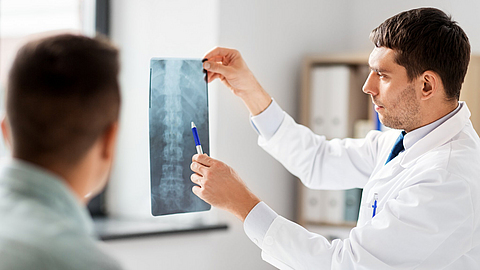 Arzt zeigt dem Patienten in der Arztpraxis Röntgenbilder | © Syda Productions - stock.adobe.com Arzt zeigt dem Patienten in der Arztpraxis Röntgenbilder