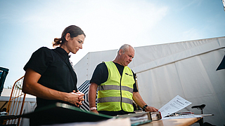 Dokumentation ist alles: Clara Seipp von Sunny Side Catering und BGN-Arbeitsschutzexperte Stephan Thomassohn prüfen die Unterlagen.