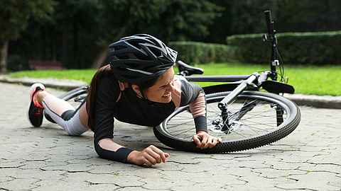 Junge Frau ist im Park vom Fahrrad gefallen