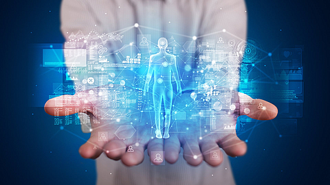 Junge Person, die eine Hologrammprojektion mit gesundheitsbezogenen Grafiken und Symbolen hält