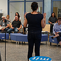 Gesundheitsmanager sichten Infomaterialien und unterhalten sich darüber an einem Tisch.