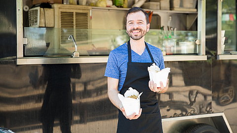 Foodtruck-Besitzer mit Essen | © AntonioDiaz - stock.adobe.com Foodtruck-Besitzer mit Essen