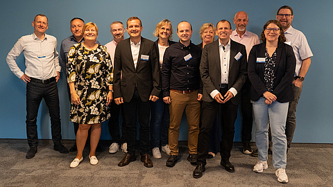 Gruppenfoto vom Vision-Zero-Kooperationspartnertreffen, 12 Leute lächeln in die Kamera
